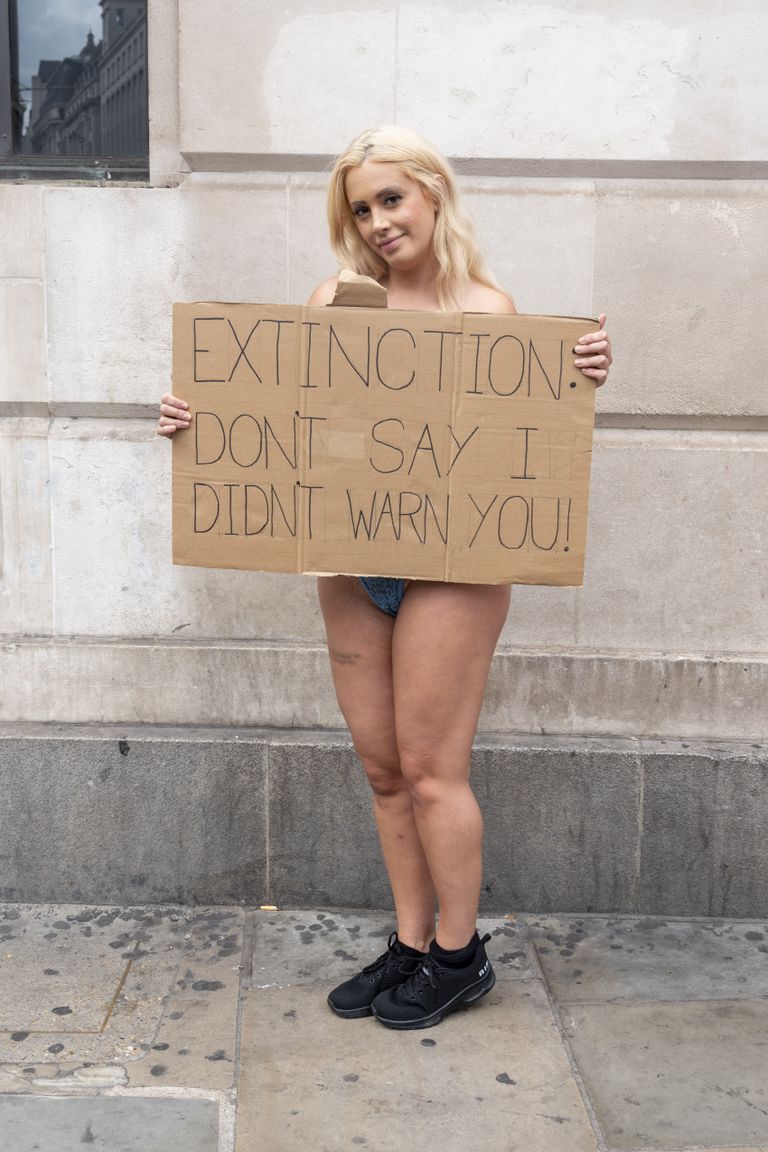 Laura Amherst plakatiga, millel on kirjas: «Väljasuremine: ära ütle, et ma sind ei hoiatanud!»