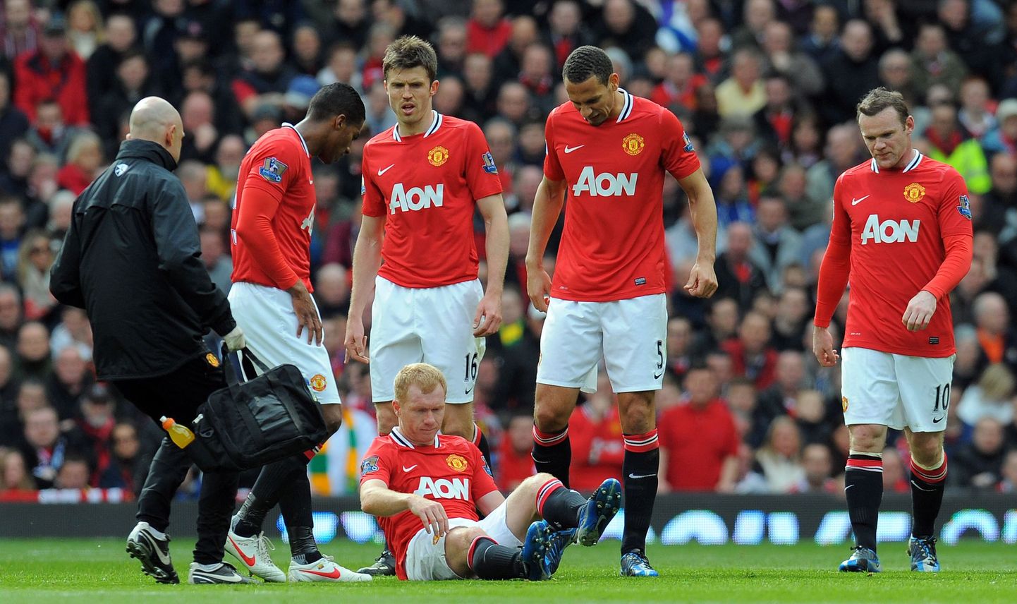 Manchester Unitedi mängija Paul Scholes vigastatuna murul istumas.