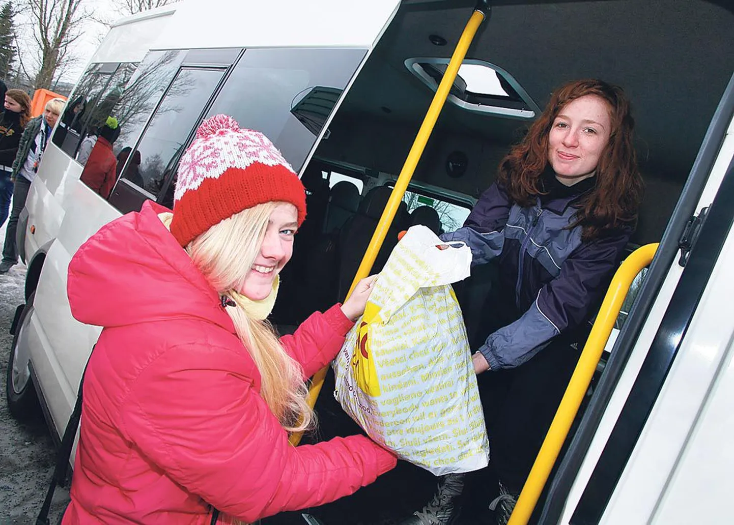 Kilingi-Nõmme gümnaasiumi 12. klassi õpilased Gerly Pikkor (vasakul) ja Kertu Kore tõstavad Pärnu kodutute loomade varjupaigas bussist välja heategevusega kogutud tarvikuid.