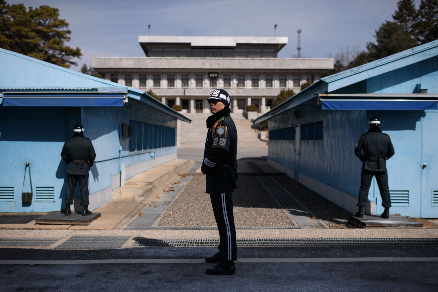 TOPSHOT - A South Korean soldier (C) stands guard before the military demarcation line and North Korea's Panmun Hall, in the truce village of Panmunjom, within the Demilitarized Zone (DMZ) dividing the two Koreas on February 21, 2018. / AFP PHOTO / Ed JONES