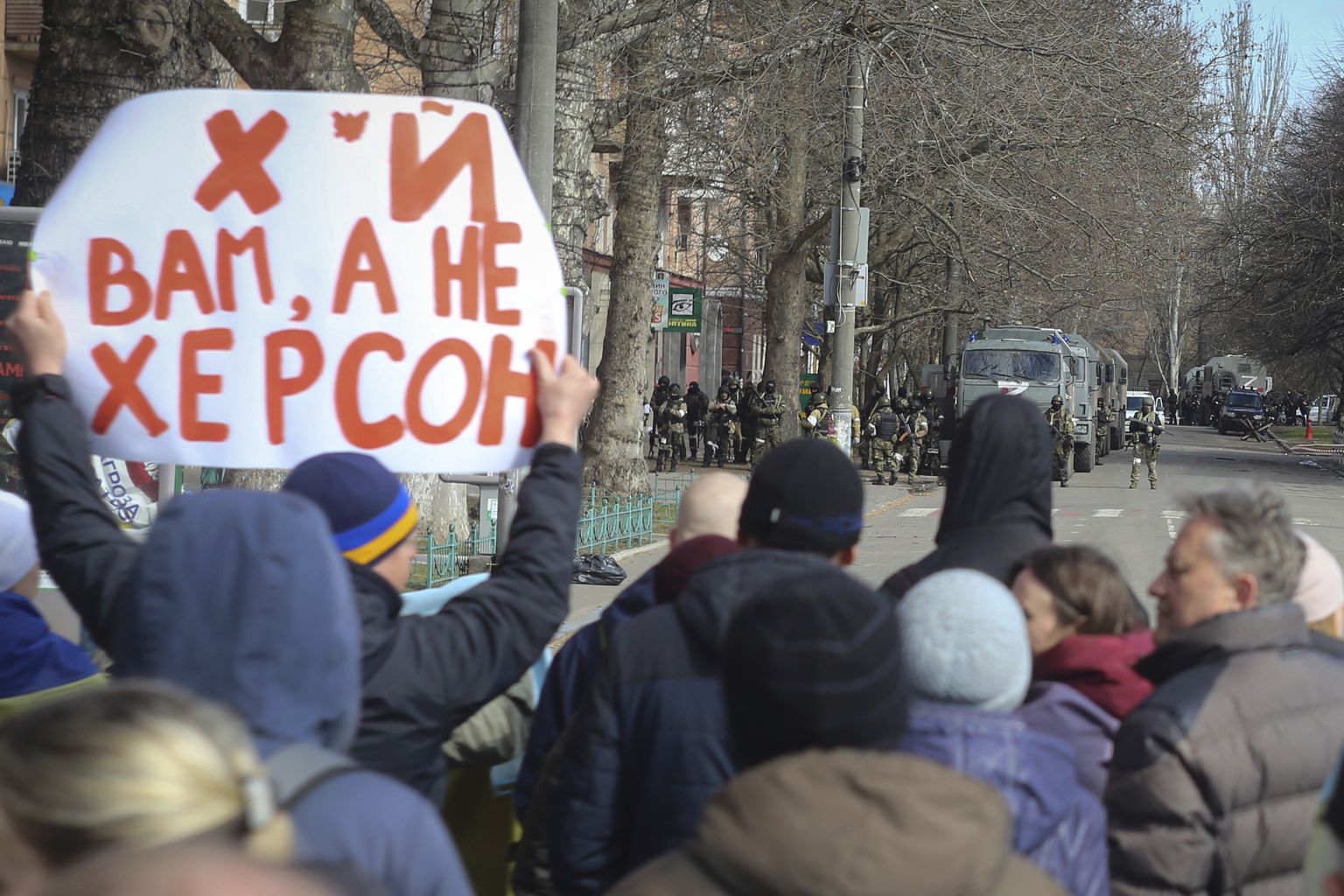 Жители Херсона стоят перед российскими войсками в центре города во время митинга против российской оккупации, 14 марта 2022 года.