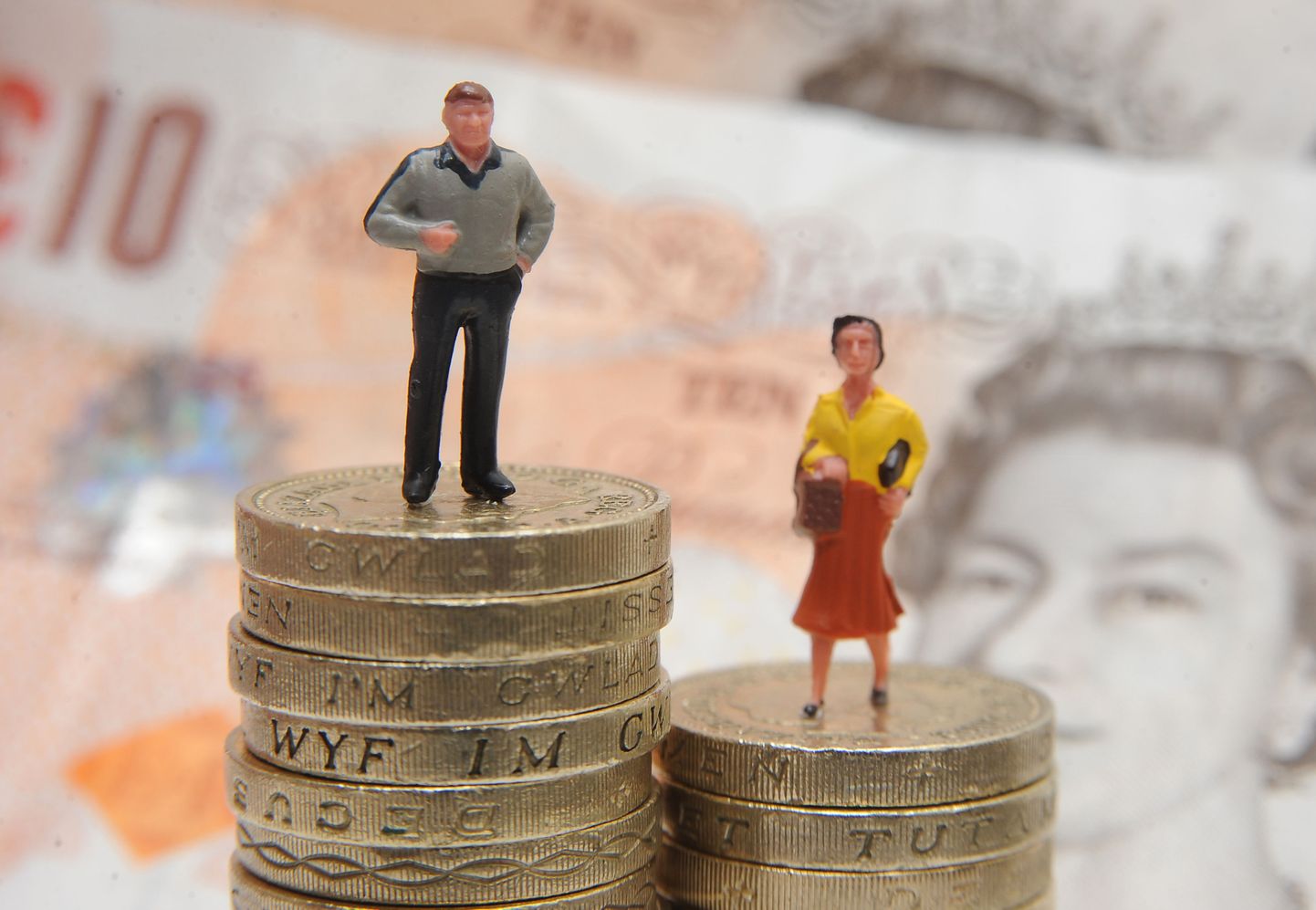File photo dated 27/01/15 of plastic models of a man and woman standing on a pile of coins and bank notes, as around half of companies required to submit their gender pay gap figures to the Government have yet to do so, with a week until the deadline.