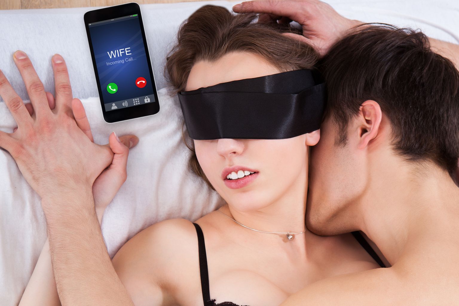 Man Kissing Sexy Blindfolded Woman In Bed