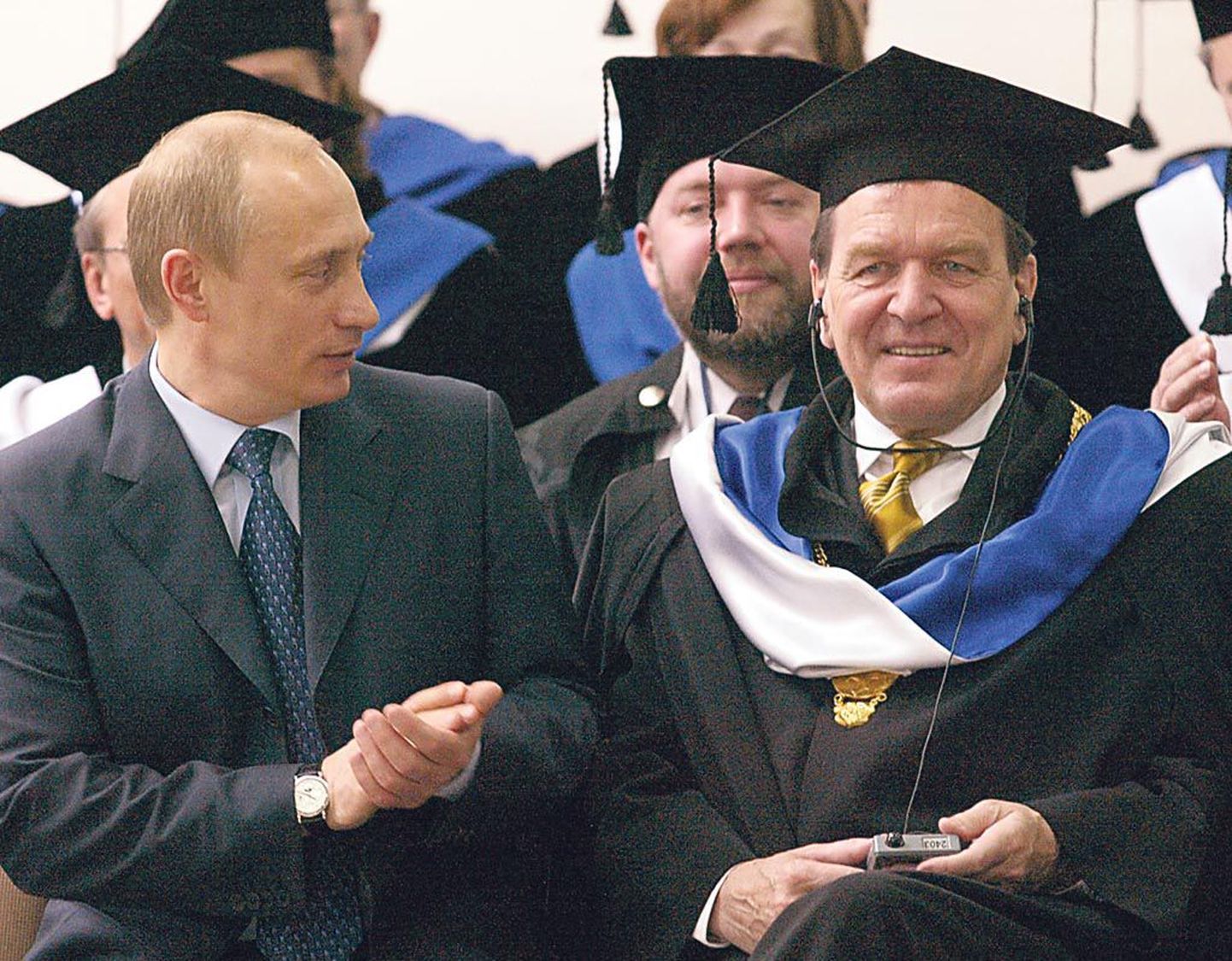 Gerhard Schröderi promoveerimine audoktoriks Peterburis 2003. aastal. Sõber Vladimir Putin vaatab heakskiitva näoga kõrvalt, kuigi audoktori mütsist on aastatega saanud marioneti oma.