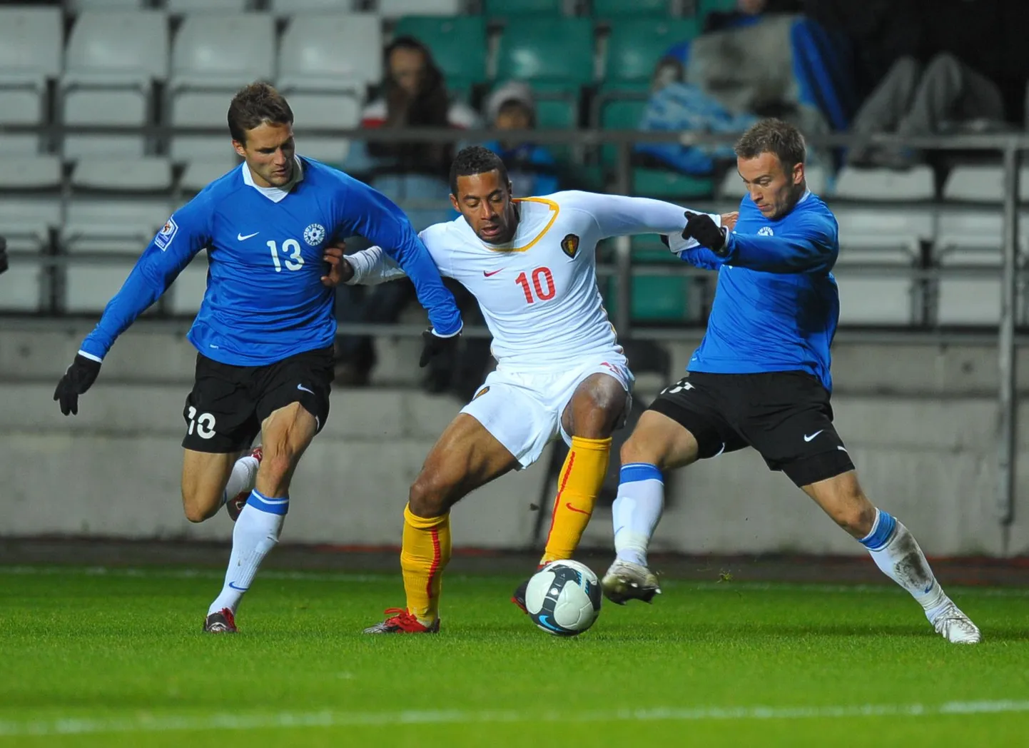 2009. aasta oktoober, Eesti-Belgia MM-valikmäng. Martin Vunk (vasakul) ja Enar Jääger on Lilleküla murul pihtide vahele võtnud Mousa Dembele.
