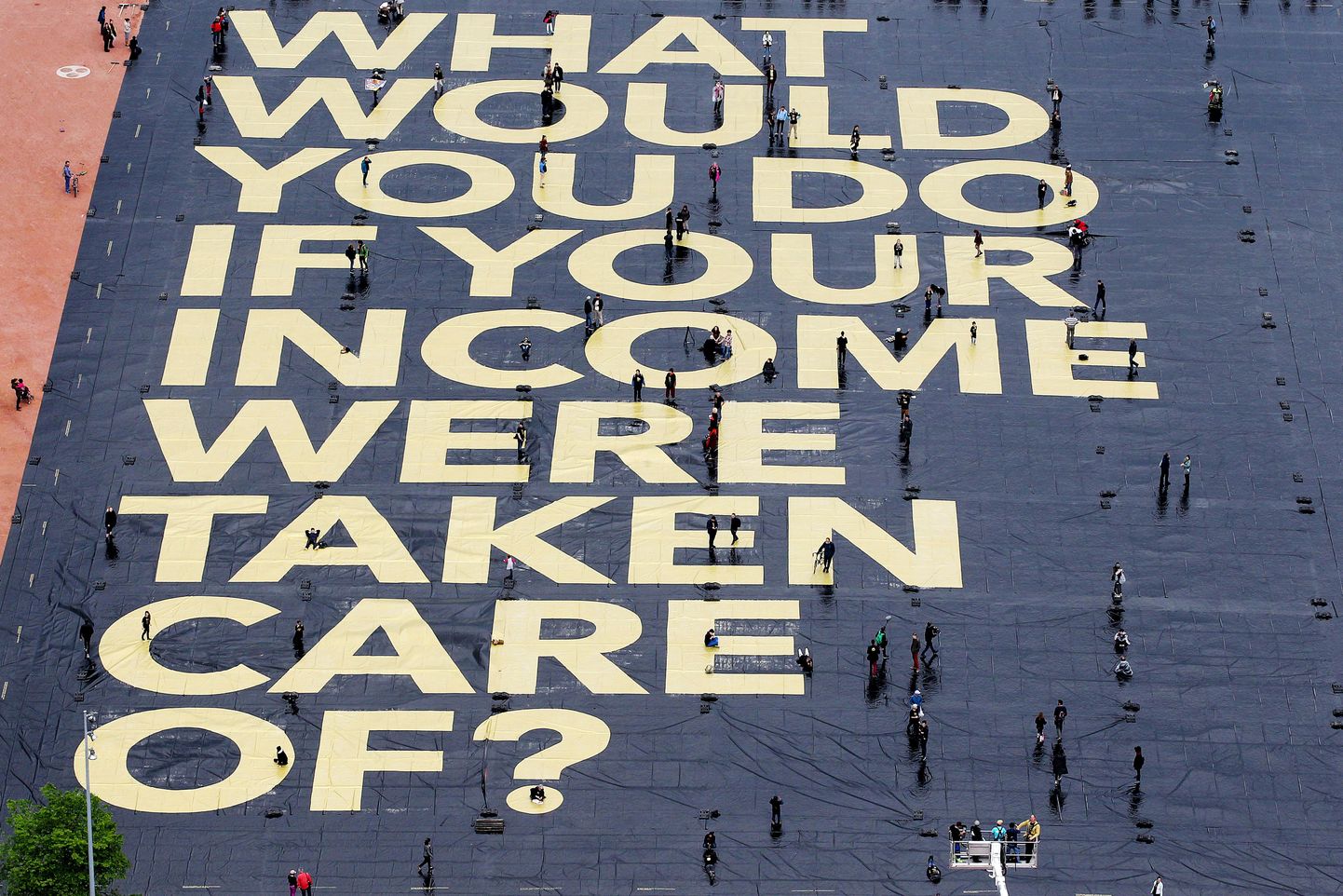 Hiiglaslik poster Šveits, Genevas, mis ütleb: «Mida sa teeks, kui sinu sissetuleku eest kantaks hoolt?» Postriga taotleti kodanikupalga loomist Šveitsis.