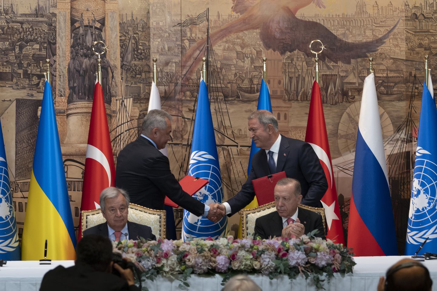 Türgi president Recep Tayyip Erdogan ja ÜRO peasekretär Antonio Guterres istuvad, kui kaks Ukraina ja Venemaa delegatsiooni esindajat  allkirjastasid tseremoonial Dolmabahce palees Istanbulis viljaekspordi kokkuleppe.
