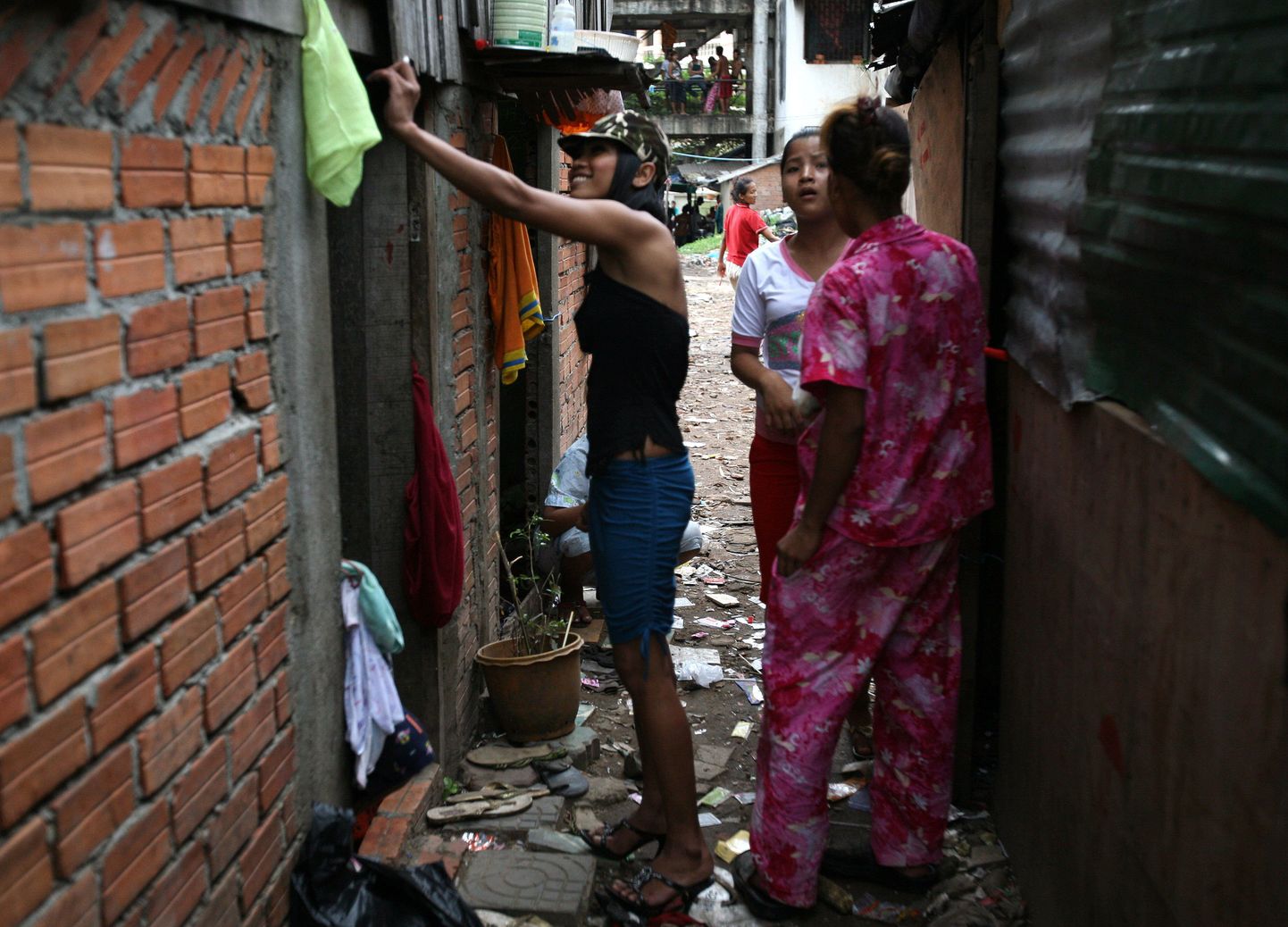 Cambodian prostitutes stand near a shelter at a slum village in Phnom Penh on June 10, 2008.  The United States said that Cambodia still needs to do more to fight human trafficking, even though an annual State Department report said the nation had made progress. AFP PHOTO/ TANG CHHIN SOTHY