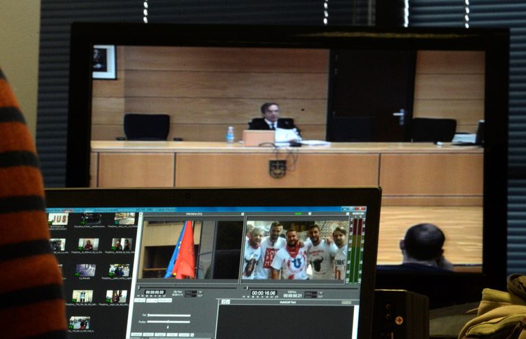 Navarra ülemkohtu kohtunik Jose Francisco Cobo loeb ette otsust. Esiplaanil oleval ekraanil on näha pilt Pamplonas 2016. aastal toimunud grupivägistamises osalenud meestest.
