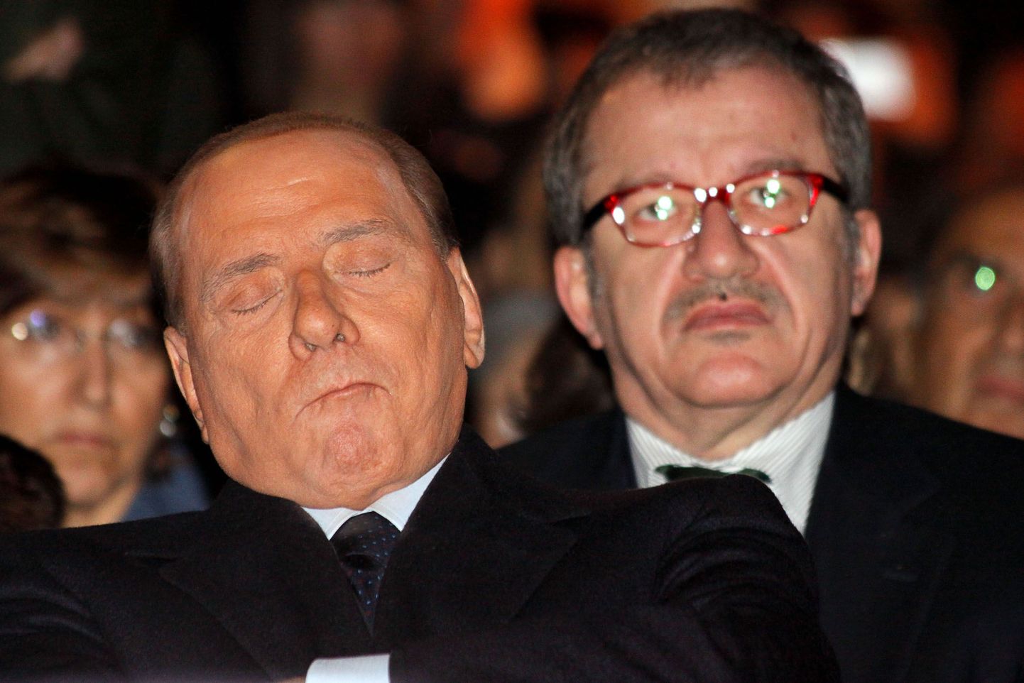 Itaalia endine peaminister Silvio Berlusconi on silma kinni lasknud holokausti mälestuspäeval Milanos. Tema selja taga paistab Põhjaliiga partei liider Roberto Maroni.