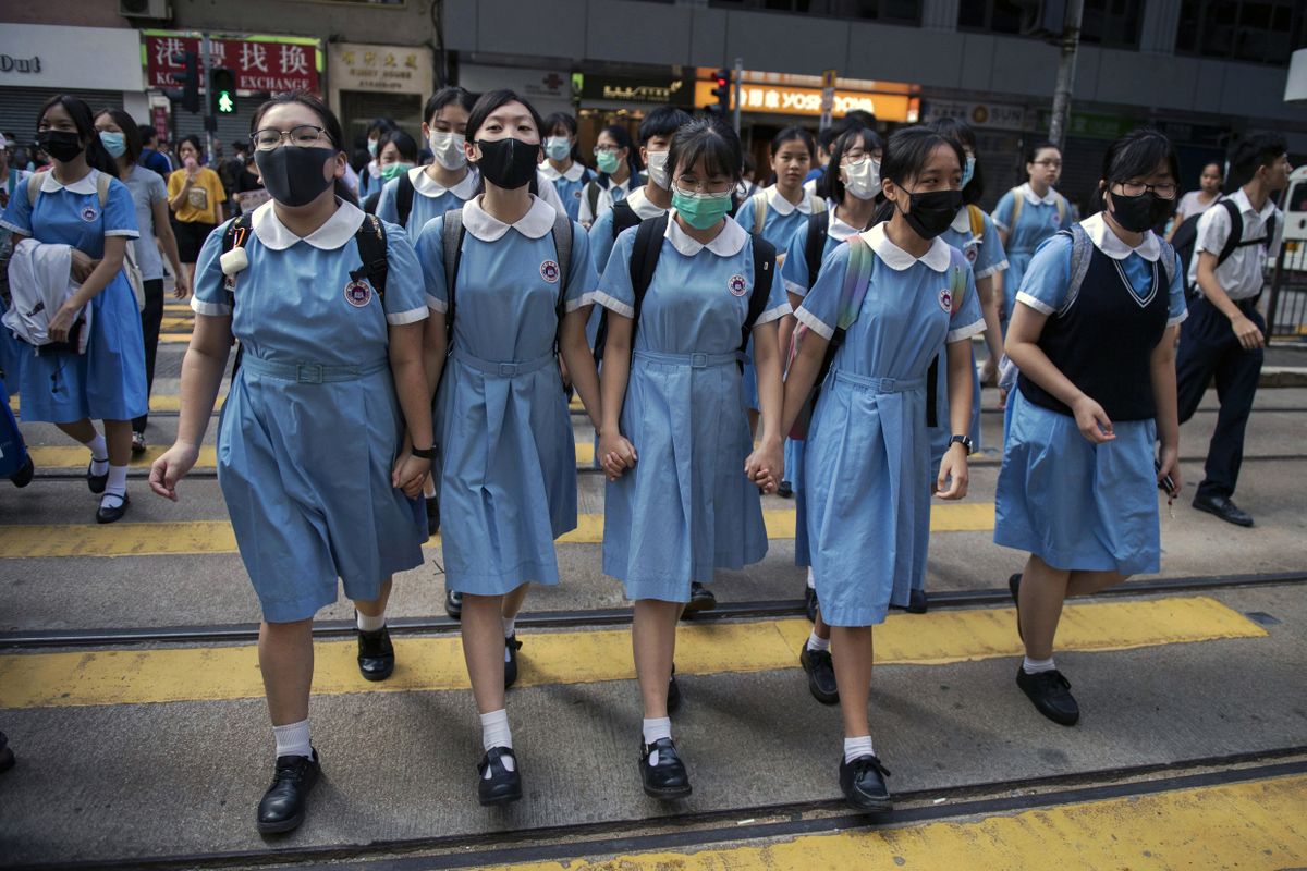 Inimketis osalenud kooliõpilased ületamas teed pärast meeleavaldust Hongkongis 12. septembril 2019.