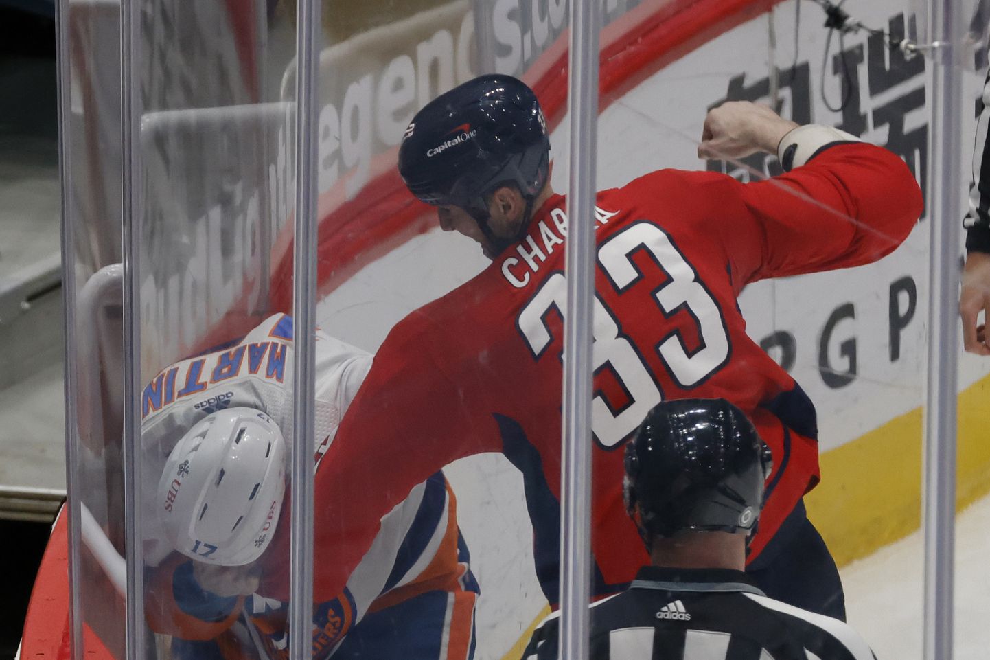 NHLi jäähokiklubi Washingtoni Capitalsi kaitsemängija Zdeno Chara (nr 33) klobimas New York Islandersi hokimeest  Matt Martinit (nr 17).