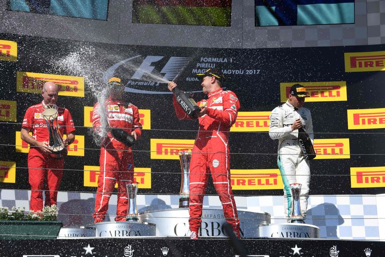 Ungari GP 30. juulil(vasakult paremale): Ferrari insener Jock Clear, teiseks tulnud Kimi Räikkonen, võitja Sebastian Vettel ja kolmanda koha saanud Valtteri Bottas