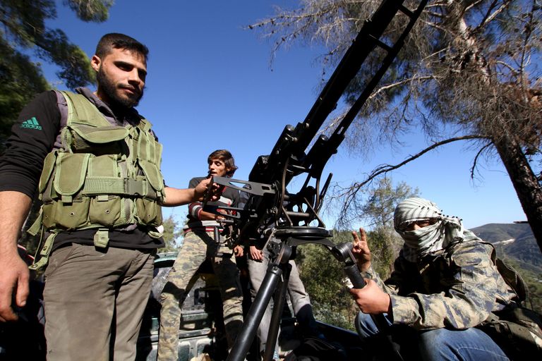 Süüria turkmeenidest võitlejad õnnetuspaiga lähedal õhutõrjekahuri juures poseerimas. Foto: Reuters/Scanpix