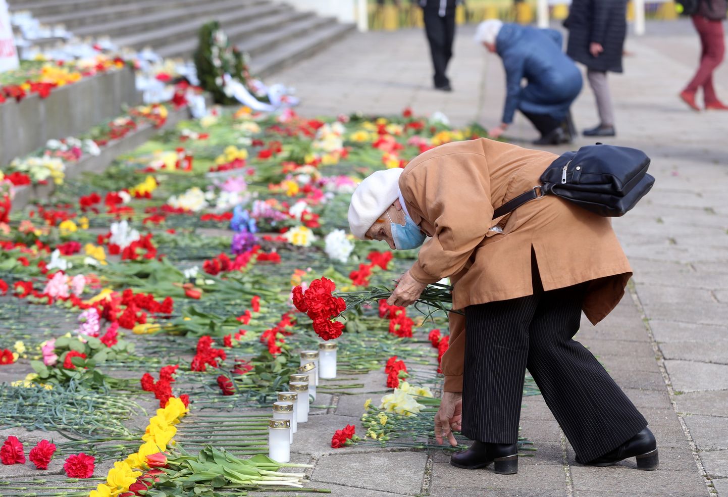 Siviete noliek ziedus pie pieminekļa "Padomju Latvijas un Rīgas atbrīvotājiem no nacistiskajiem iebrucējiem" Otrā pasaules kara piemiņas pasākumā Uzvaras parkā.
