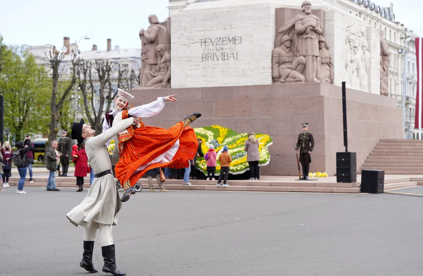 Танцоры на площади у памятника Свободы, где создают традиционную "Цветочную Латвию"