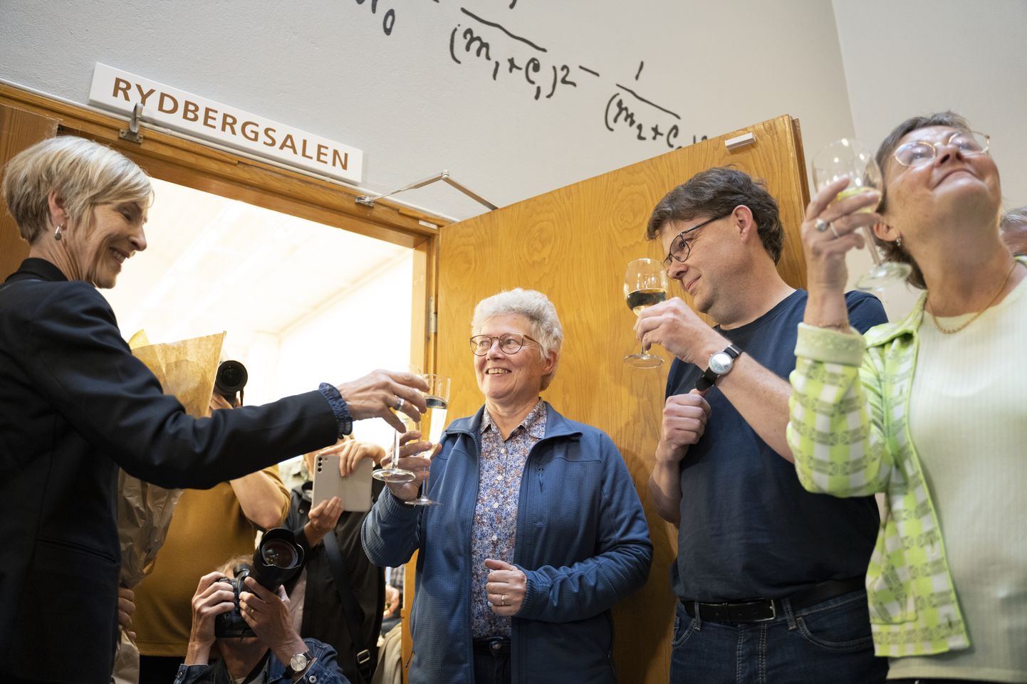 Нобелевский лауреат Анн ЛʼЮилье празднует победу среди коллег и студентов.