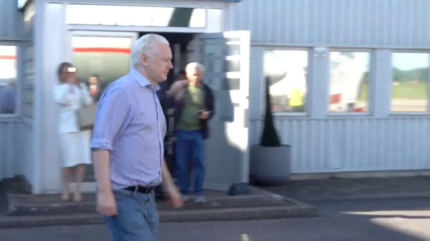 Julian Assange Londonis lennukile minemas.
