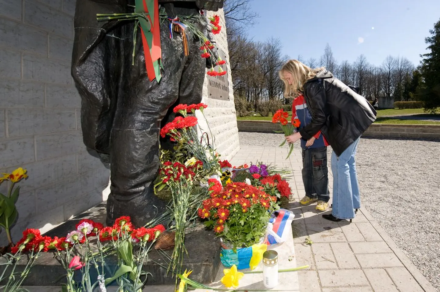 Inimesed viimas lilli pronkssõduri juurde.
