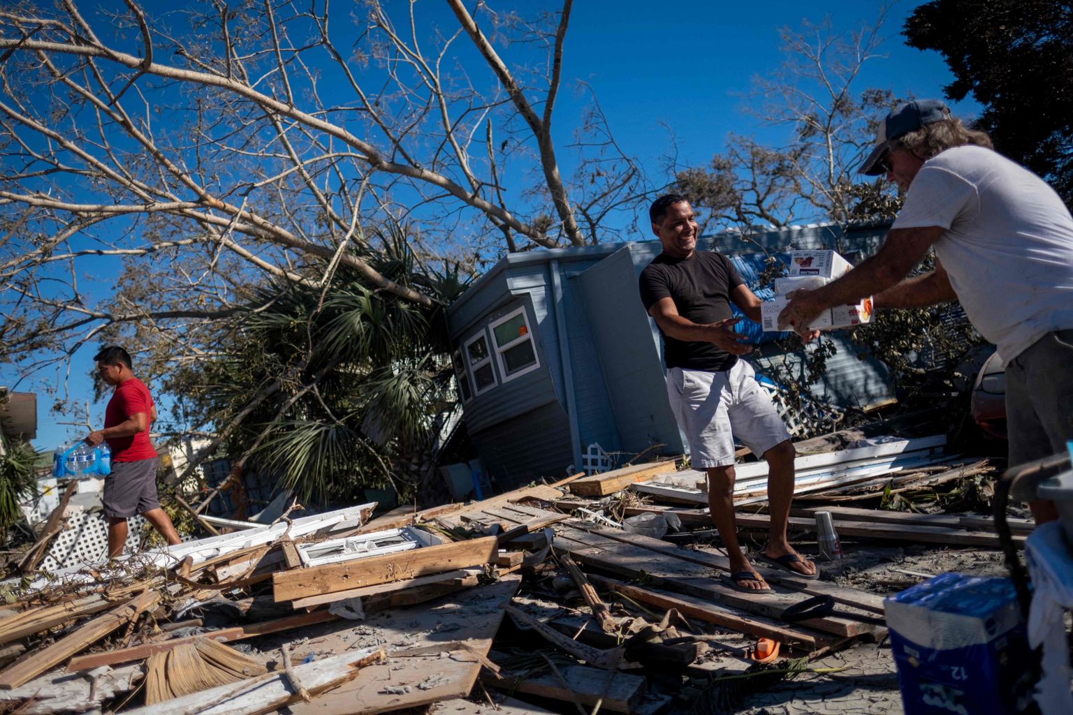 Jose Ramirez võtab pärast orkaani Ian laastamist naabrilt vastu toidukraami Florida osariigis Fort Myers Beachil.