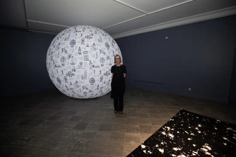 Krista Leesi kahe oma teose vahel: selja taga on «Toile, Tartu ja Tolly maja» ning ees «Shit Happens».