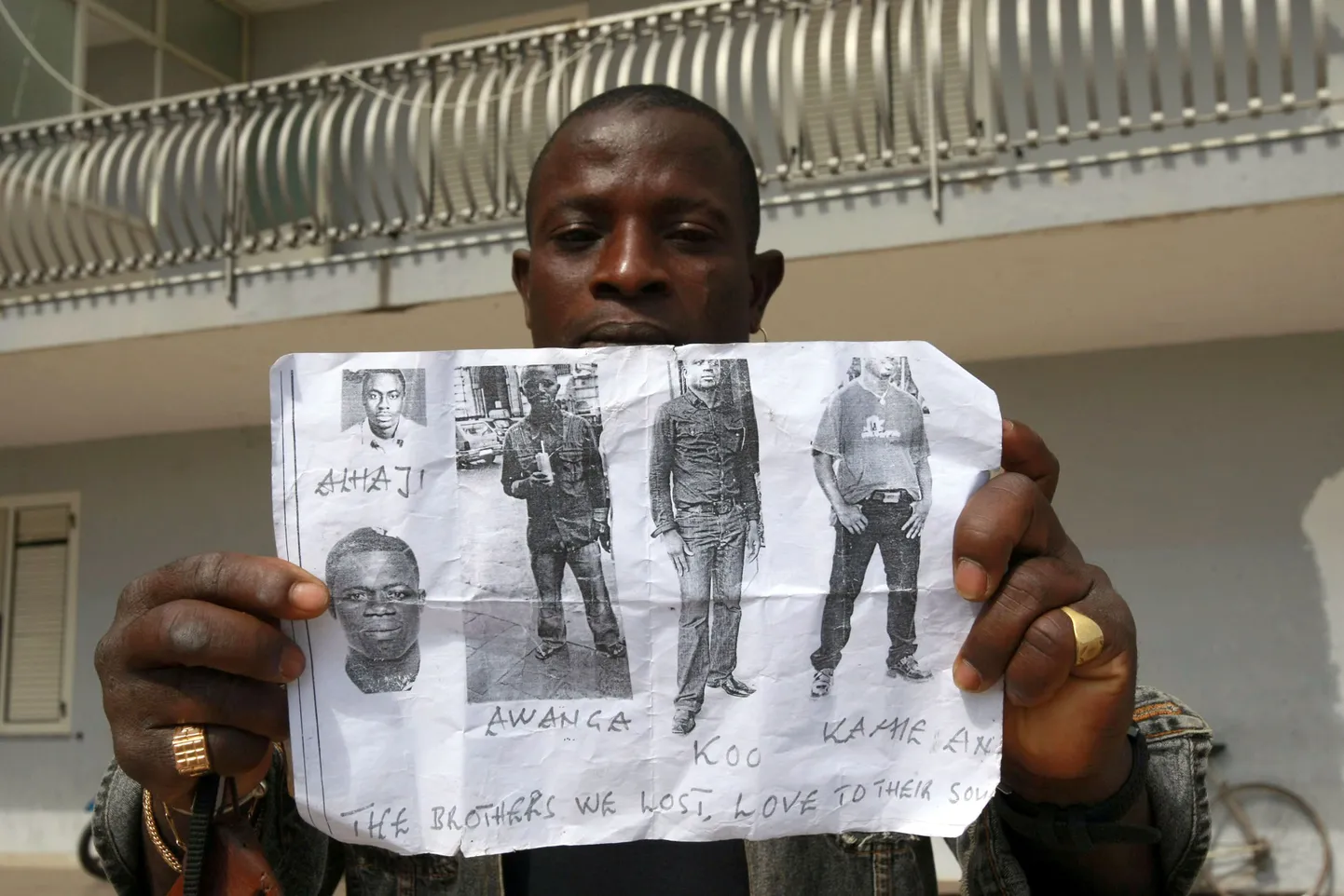 Mees näitab Napoli lähedal tapetud  aafriklaste pilte.