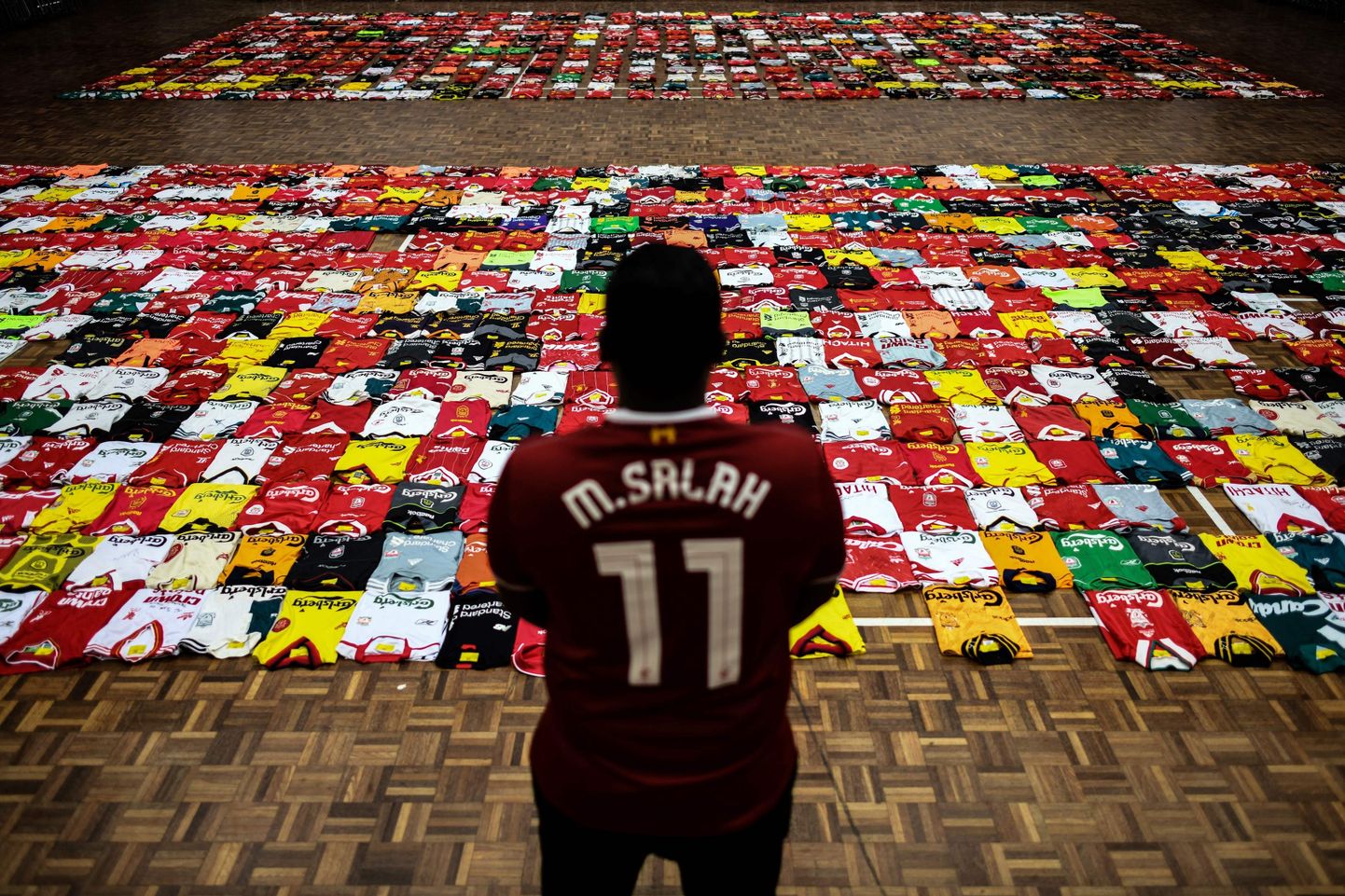 Liverpool on globaalse haardega jalgpalliklubi, kelle matše Meistrite liiga poolfinaalis jälgitakse igas maailma otsas. Fotol silmitseb Mohamed Salahi särki kandev Liverpooli fänn Malaisias välja pandud näitust erinevatest Liverpooli mänguvormidest.