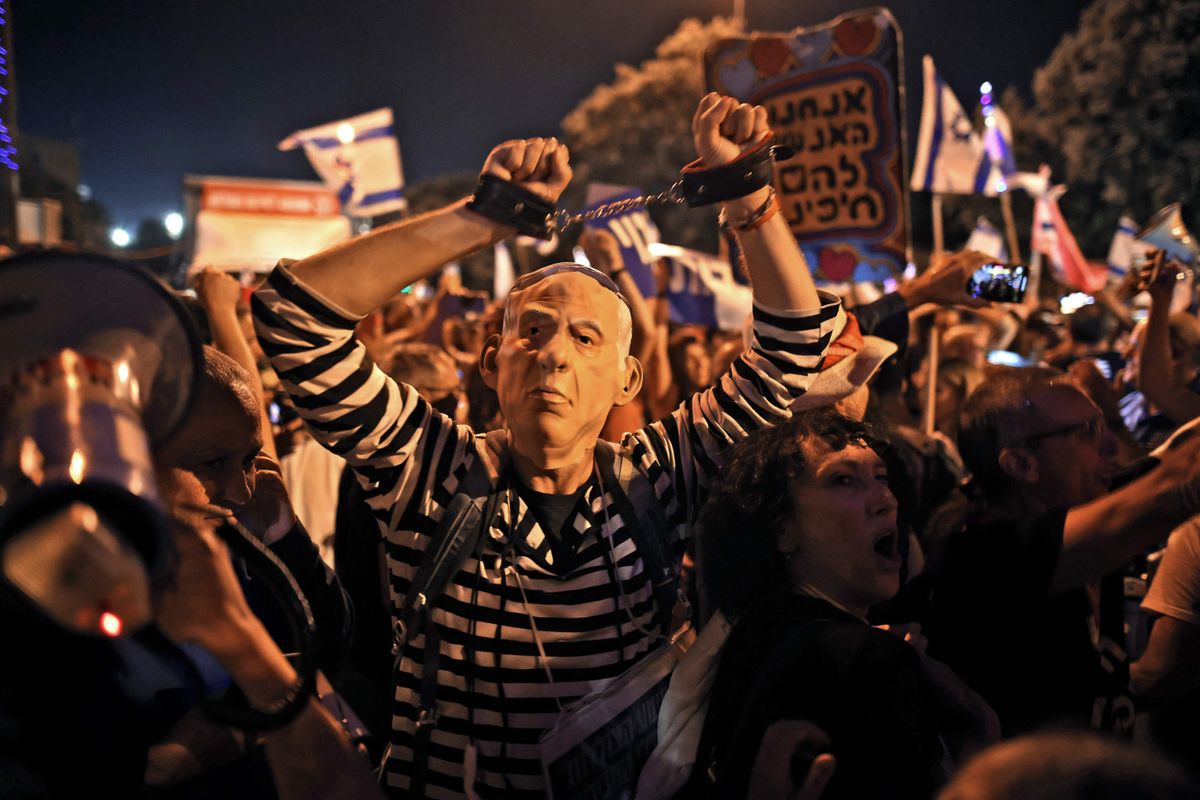 Benjamin Netanyahu langemine tõi Tel Avivis kaasa suured tähistamised. Pildil käeraudade ja vanglariietusega Netanyahu maski kandev demonstrant, kes juhib tähelepanu Netanyahu vastu esitatud korruptsioonisüüdistustele. 