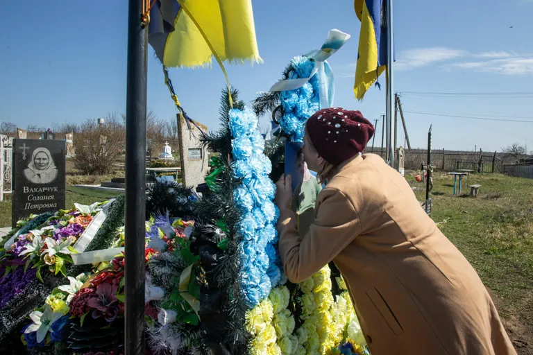 Светлана Олинык у могилы своего 22-летнего сына Андрея, который погиб на войне. Могила до сих пор утопает в цветах. По словам матери, её часто навещают сослуживцы Андрея из морской пехоты и его друзья.