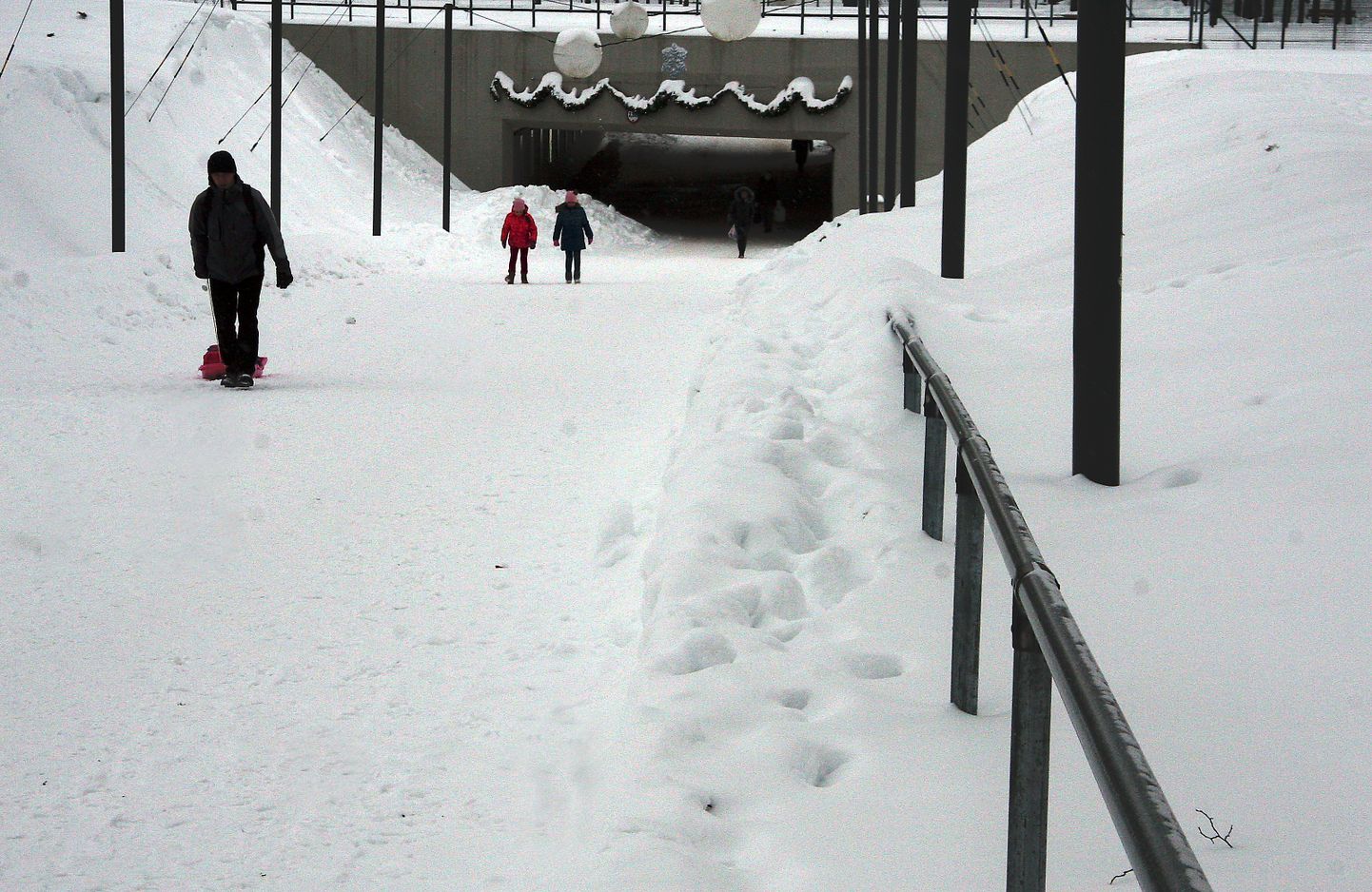 Jõhvi promenaadil asuva jalakäijate tunneli juures on jalgteed puhastatud nii, et käsipuu on kohati lumme uppunud ning lumevall takistab selle kasutamist.