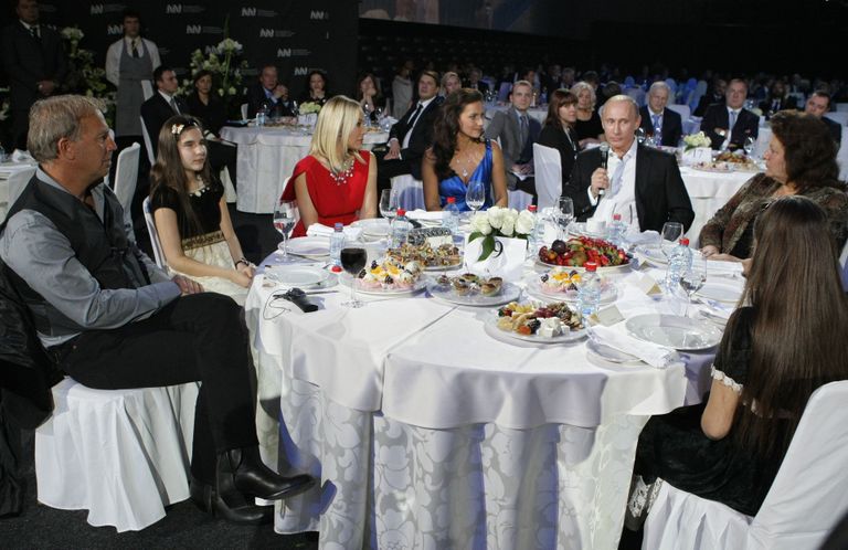 Vladimir Putiniga (mikrofoniga) istusid ühe lauas näiteks Itaalia näitlejanna Ornella Muti (punase kleidiga) ja Hollywoodi staar Kevin Costner (vasakul). / Scanpix