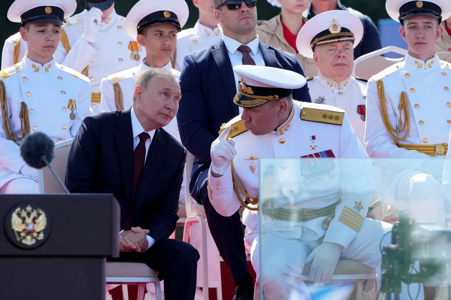 Путин на фоне охранников и скучающих юных моряков слушает одного из их командиров. День ВМФ, 28 июля 2024 года, Санкт-Петербург.