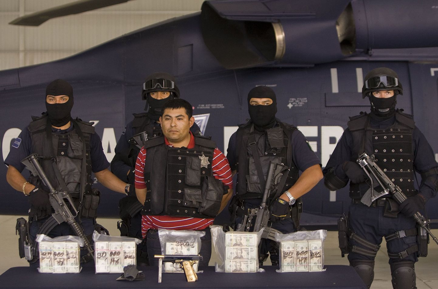 Palgamõrvar Jaime Gonzalez Duran koos temalt konfiskeeritud relva ja rahaga