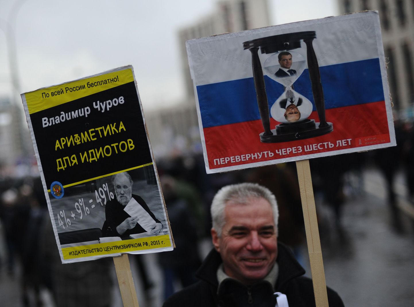 Loosunginäiteid 24. detsembri rahvakogunemiselt Moskvas. Putini ja Medvedevi pildiga liivakella juurde on  kirjutatud, et see tuleb kuue aasta pärast pöörata ümber. Paremal on aritmeetika idiootidele -- 4% + 9% = 49%.