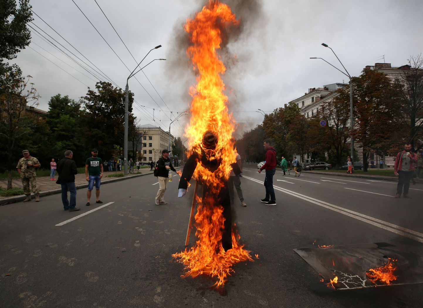 Демонстранты сжигают чучело Путина.