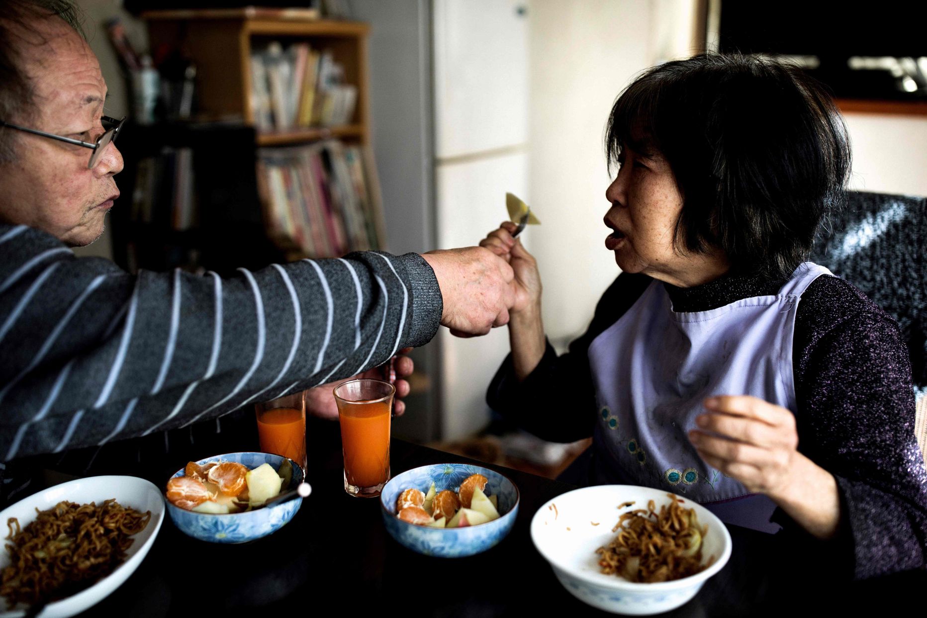 In this picture taken on January 10, 2017, Kanemasa Ito (L) feeds his dementia-stricken wife Kimiko at their house in Kawasaki.
One of the world's most rapidly aging and long-lived societies, Japan is at the forefront of an impending global healthcare crisis. Authorities are bracing for a dementia timebomb and their approach could shape policies well beyond its borders. / AFP PHOTO / BEHROUZ MEHRI / TO GO WITH Japan-society-ageing-dementia,FEATURE by Natsuko FUKUE