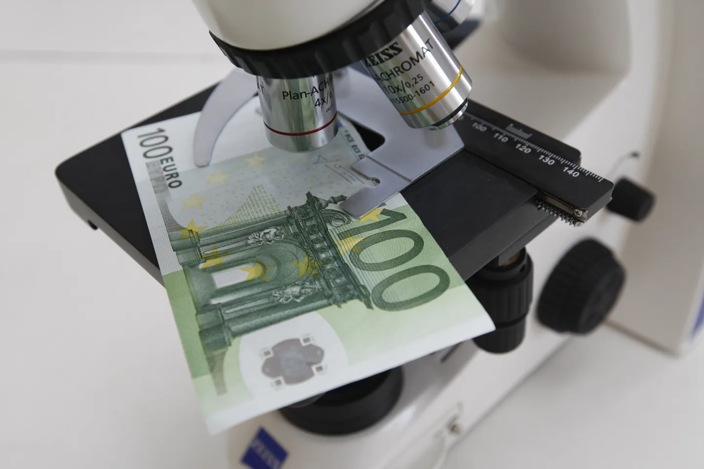 100 eurone mikroskoobi all. Pilt on illustratiivne.