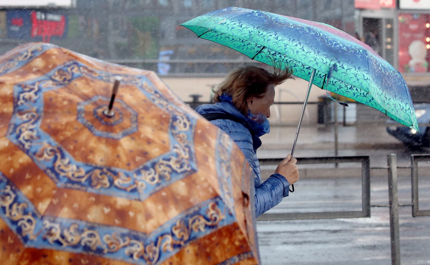 Sieviete ar lietussargu negaisa laikā.