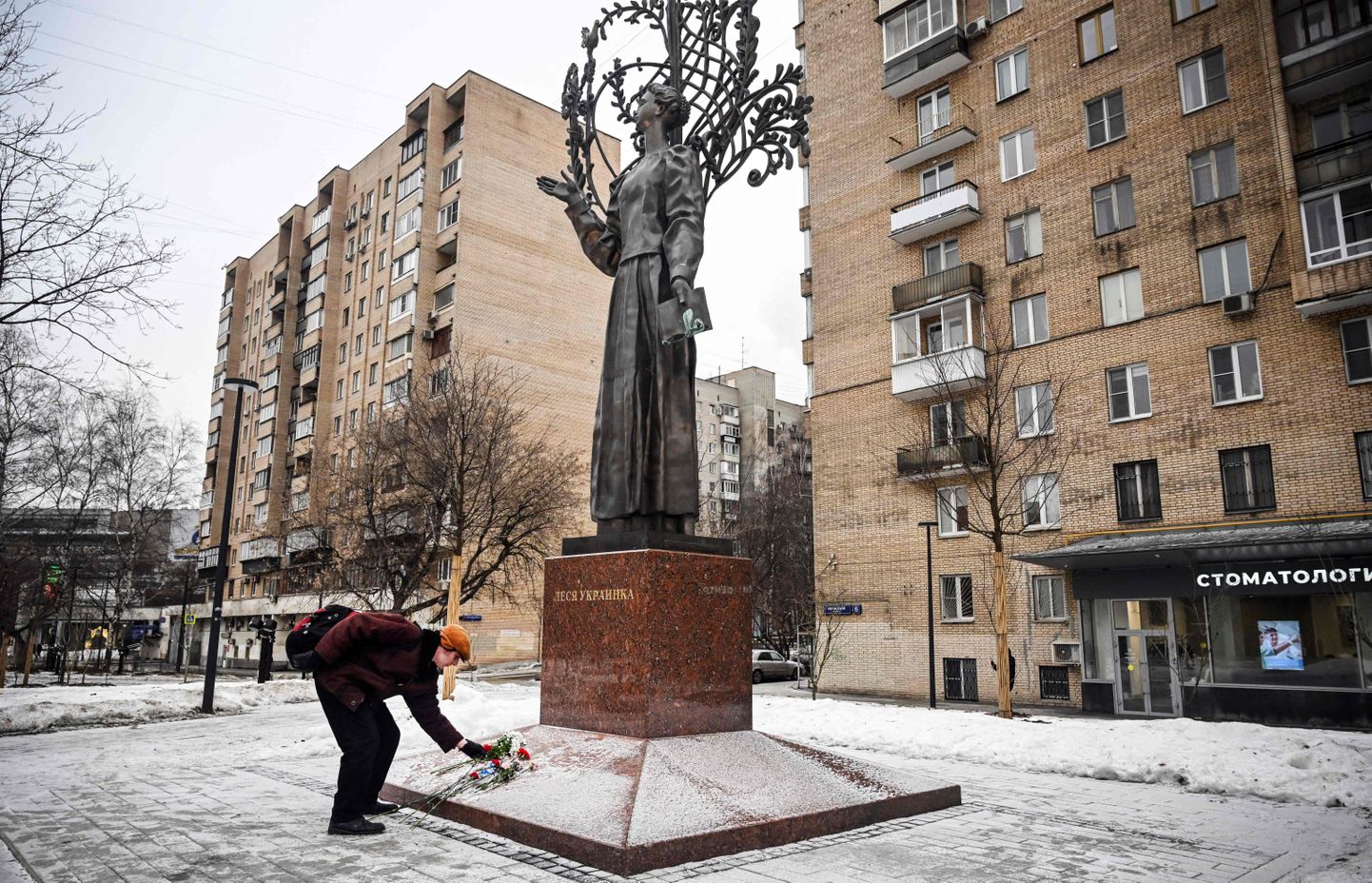 Мужчина возлагает цветы к статуе украинской поэтессы Леси Украинки в Москве.