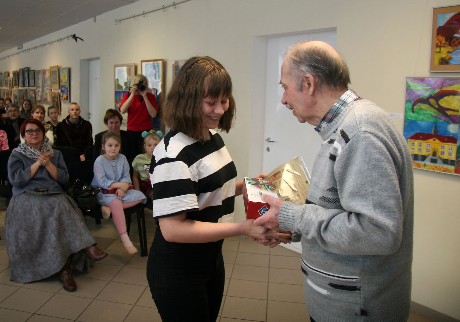 Элиза Мария Сахтель из Тапаской школы музыки и искусства получает подарок из рук известного ида-вируского художника Евгения Колпакова.