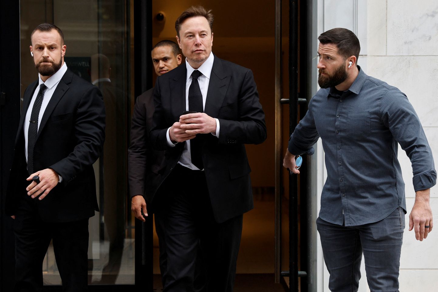 Elon Musk lahkumas 27. jaanuaril 2023 koos oma ihukaitsjatega USAs Washingtonis Tesla kohalikust kontorist