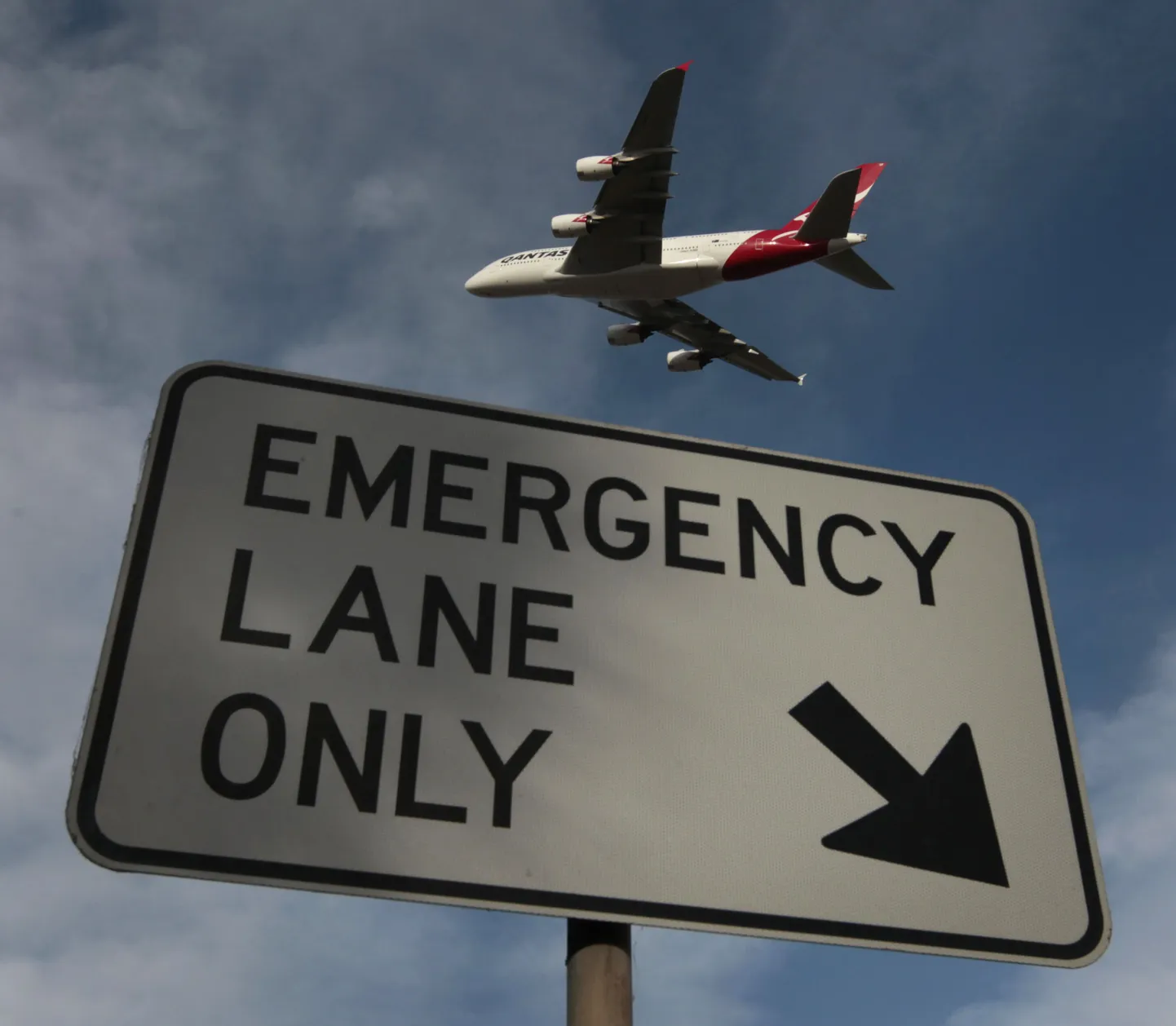Näide nii-nimetatud "sümbolpildist", kus Reutersi fotograaf on pildistnud mainekriisi ajal maanduvat Qantase lennukit sildi "hädamaandumisrada" taustal.