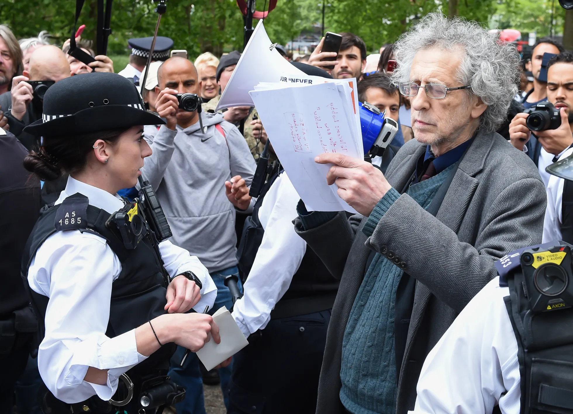 Pildil on endise Suurbritannia tööpartei juhi Jeremy Corbyni 73-aastane vend Piers Corbyn, keda nähti meeleavalduse ajal mõni aeg ka käeraudades. Pealtnägijate sõnul väitis Corbyn, et vaktsiin ei ole vajalik, ning seostas koroonaviiruse pandeemiat 5G vandenõuteooriaga.