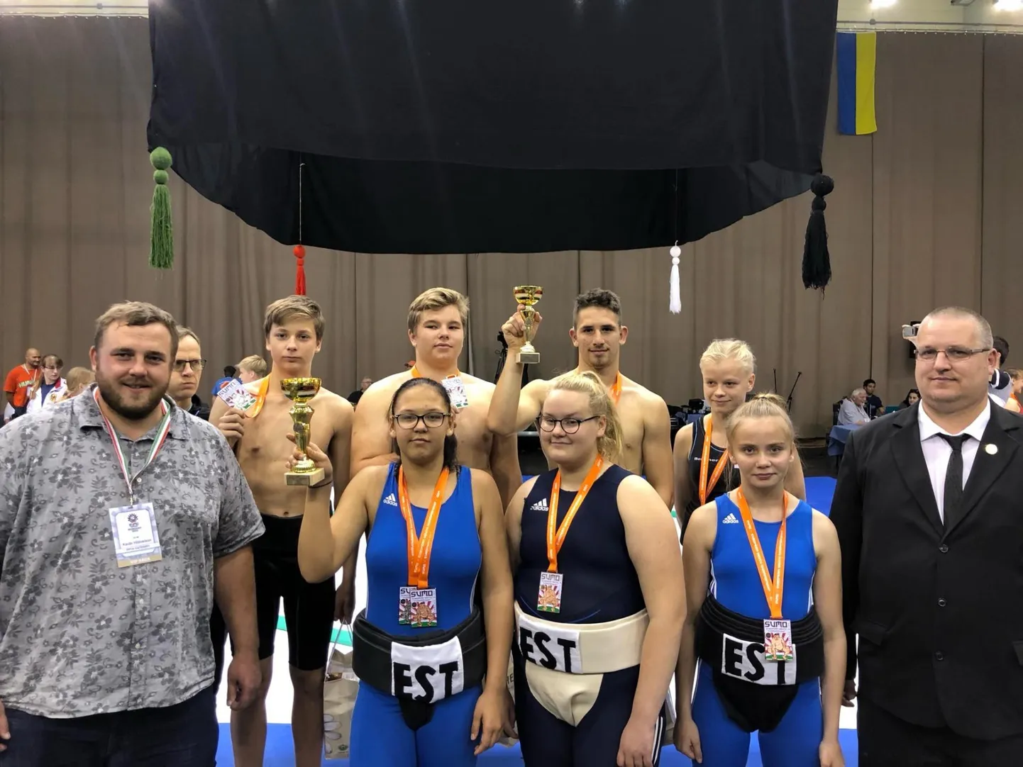 Noorte Euroopa meistrivõistlused sumos kujunesid Eestile taas edukaks. Sportlasi toetasid kohapeal alaliidu vastne president Kaido Höövelson (vasakul) ning Eesti Karude treener Meelis Höövelson (paremal).
