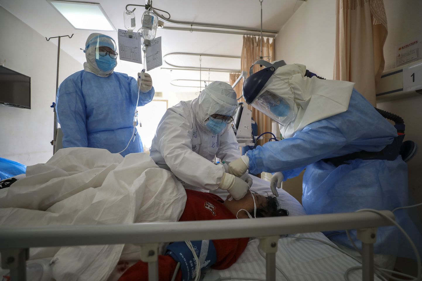 Врачи  уханьской больницы занимаются пациентом с коронавирусом.