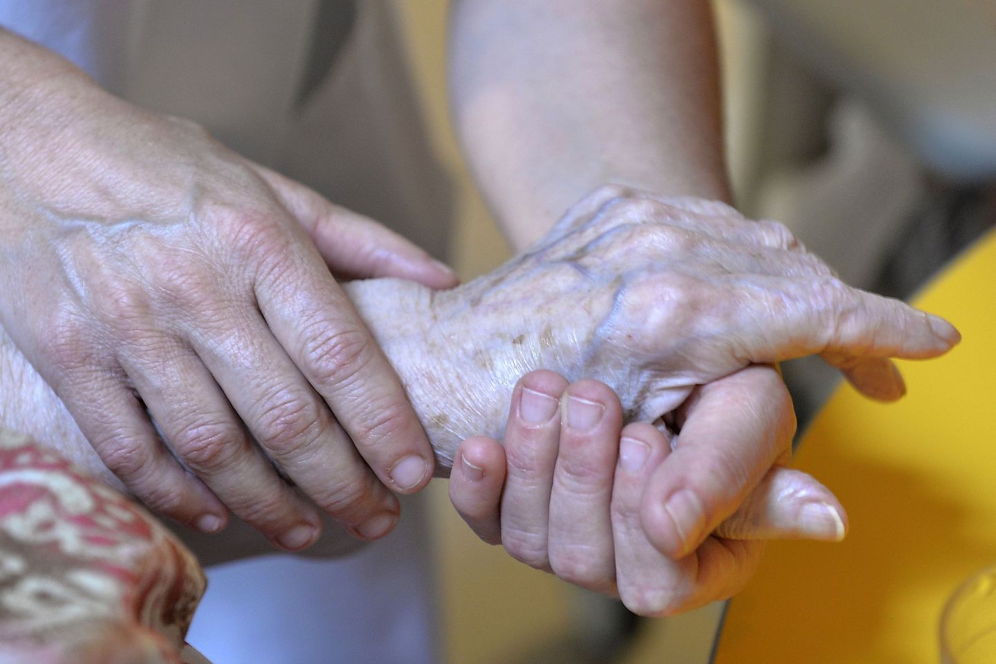 Vanaldane inimene hoidmas arsti kätt.