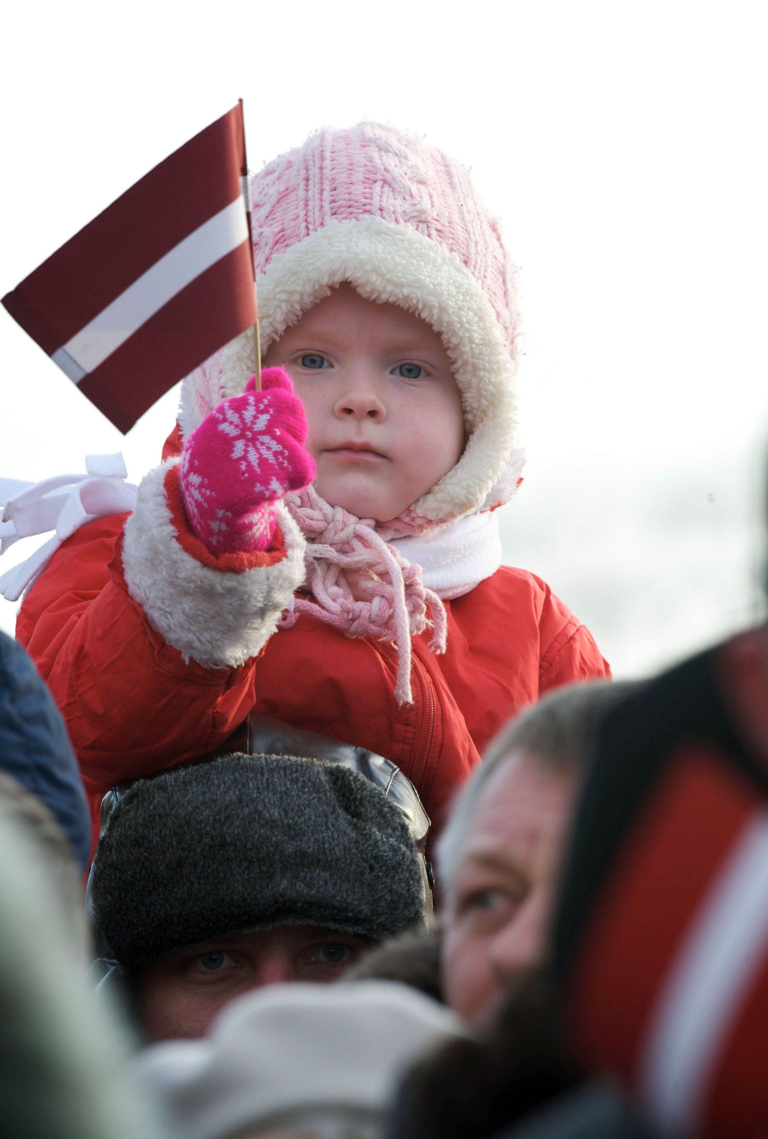 Ребенок держит флаг Латвии.