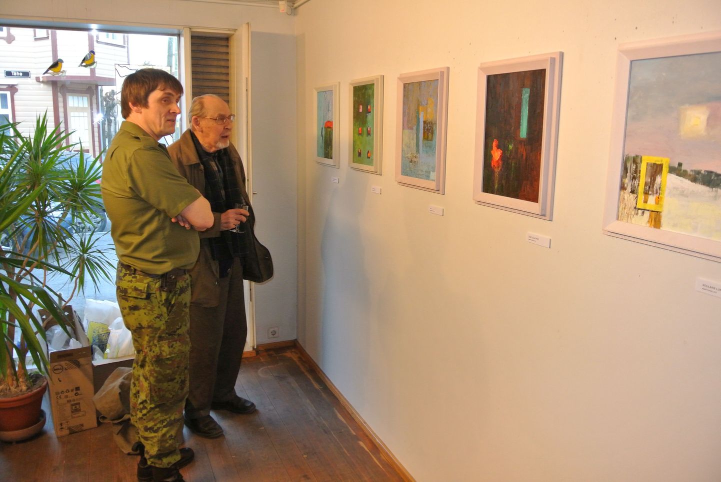Kaitseliitlase vormis kunstnik Martti Ruus tutvustas näituse avamisel väljapandud pilte oma maaliõpetajale Heldur Viiresele. Nende ees on maalid «Katus sõidab» (vasakult), «Kuus teist», «Kiil», «Ühe lille pilt» ja «Kollane lumi».