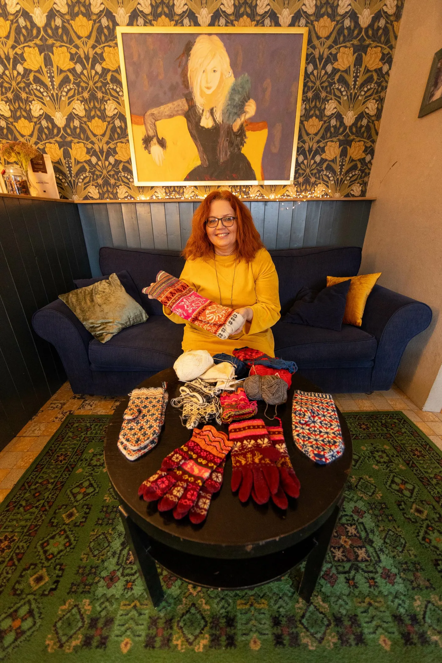 Novembrisse värve. Tiina Lippant näitab Paide Wabakohvikus oma kaunist käsitööd. Käes on tal Muhu sukad ning laual Vigala labakud ja Muhu sõrmikud. Pooleliolevad punase-sinisekirjud kindad on Lihula mustriga.