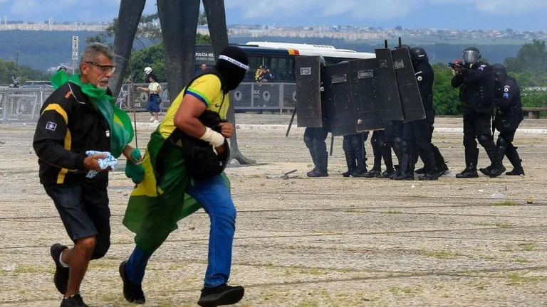 Силы безопасности противостоят сторонникам бывшего президента Бразилии Жаира Болсонару, когда они вторгаются в президентский дворец Планалто в Бразилиа, 8 января 2023 года.